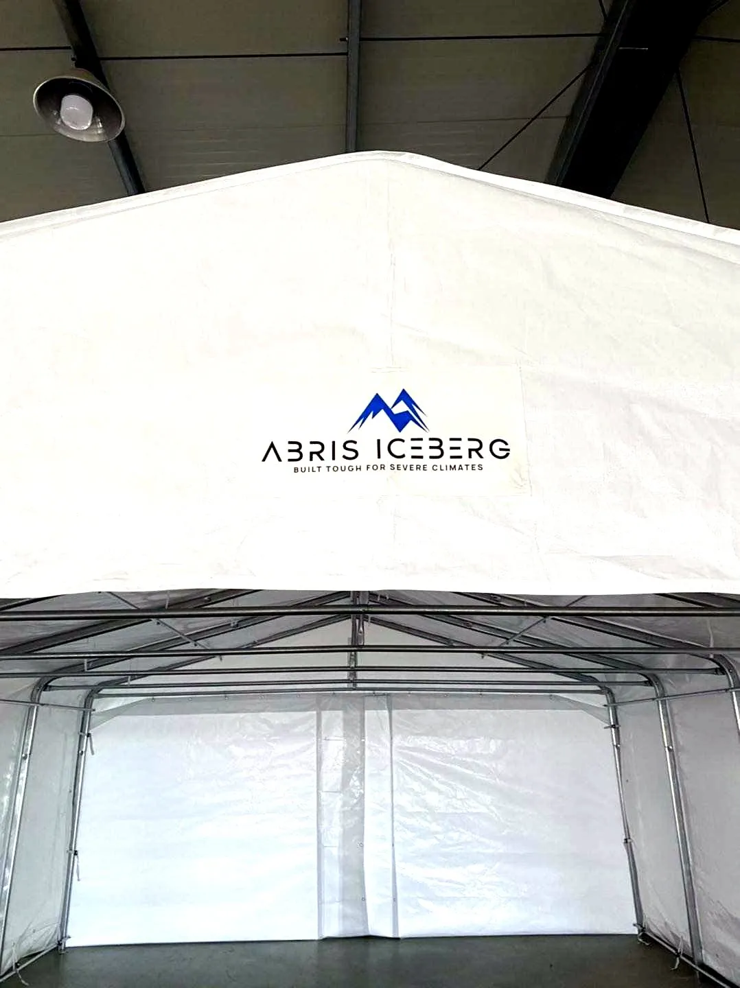 Logo Abris Iceberg et slogan sur la toile, au-dessus de l'intérieur d'un abri.